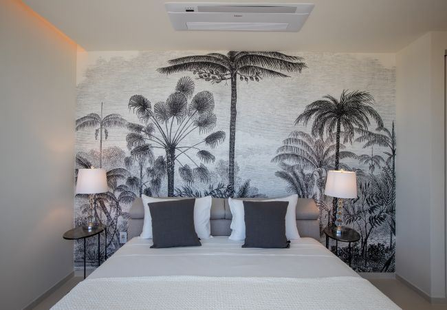 Large bedroom with a comfortable bed and tropical decoration